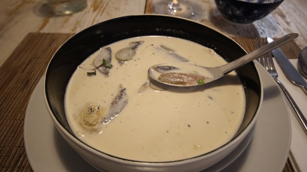 El Baruco de Anero ajoblanco malagueño, reinterpretado con leche de coco, almendra marcona, tierra de almendra, pepinillo encurtido y una sardina curada y ahumada en casa